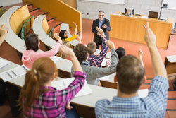 Lecturer takes questions from his students in lecture hall 