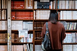 Student looks for a research book in university library 