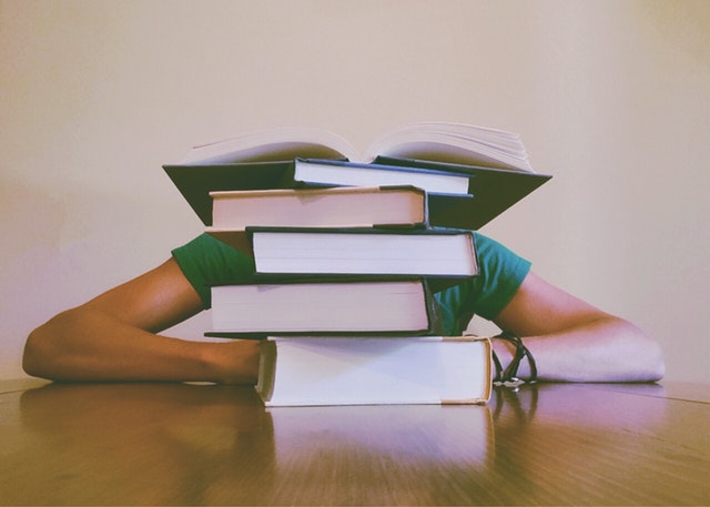 Female researcher looks defeated in the presence of numerous academic journals