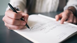 Man writes in notepad