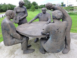 Statues of men and women appear to be discussing research ideas in local park