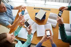 Group of graduate students take photos of academic resources in library  